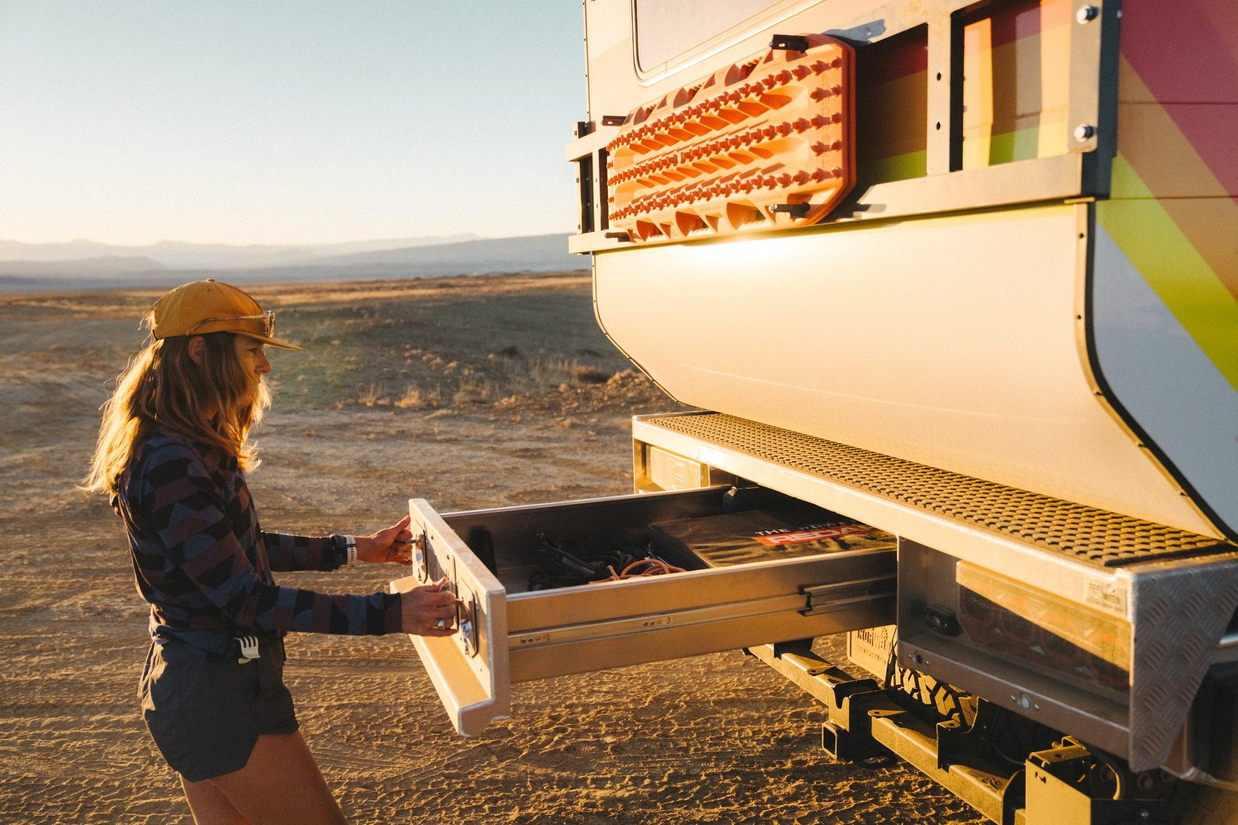 MAK standing on the ground beside the truck, pulling open the long drawer built into the rear of the flatbed tray