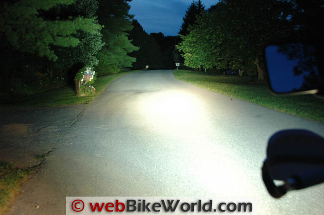 The same lane from the same position with the Krista lights added, the road lit wide and white out to the trees on both sides